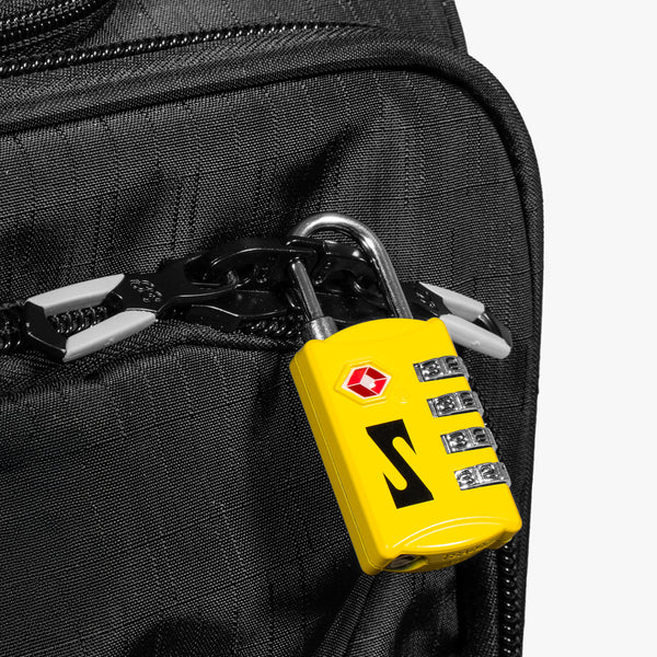 Red Scicon TSA luggage padlock with key and combination dials, designed for secure travel baggage protection.
